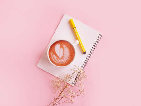 notebook  cup of coffee flower on a colored background