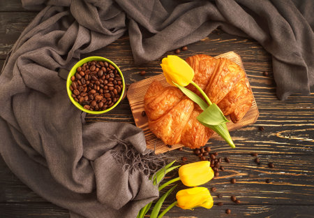 coffee, croissant, tulip flower on wooden backgroundの写真素材