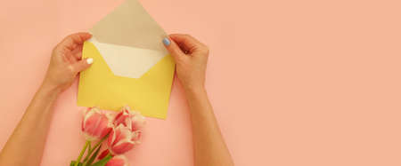 female hands hold an envelope, a bouquet of tulips