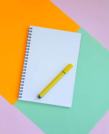 notebook, felt-tip pen on a background of colored paperの写真素材