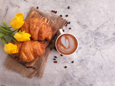 coffee, croissant, tulip flower on concrete backgroundの写真素材