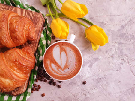 coffee, croissant, tulip flower on concrete backgroundの写真素材