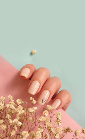 female hand beautiful beige manicure on a colored background