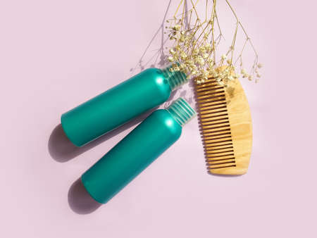 shampoo, wooden comb on a colored background