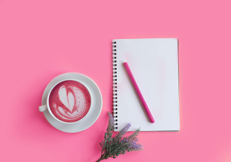 notebook, cup of coffee, gypsophila flower on colored background
