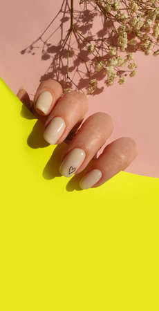 female hand beautiful beige manicure on a colored background