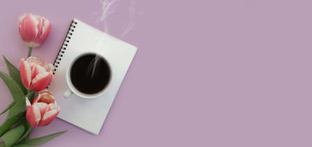 cup of coffee notebook flower tulip on colored background