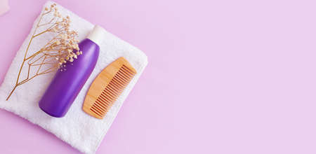 wooden comb, towel shampoo flower on colored background
