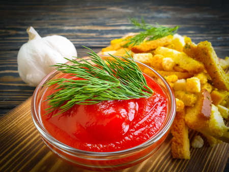 ketchup, bread croutons on a wooden background