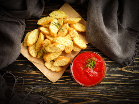 ketchup, bread croutons on a wooden background