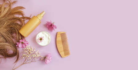 shampoo, hair, wooden comb flower on a colored backgroundの写真素材