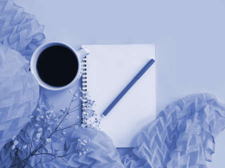 notebook, cup of coffee,  flower on colored background