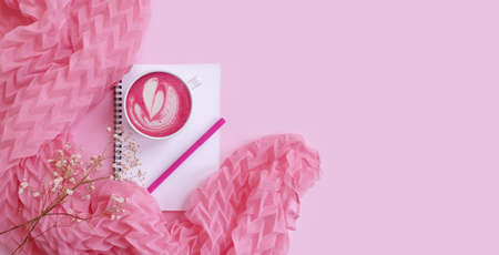 notebook, cup of coffee,  flower on colored backgroundの写真素材