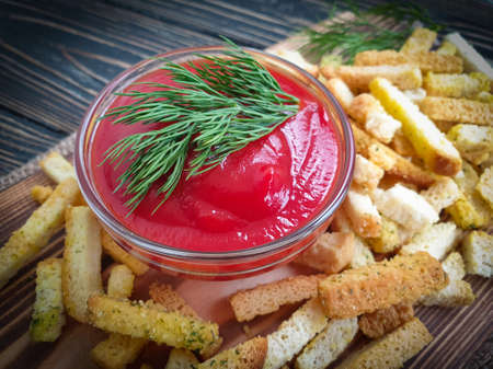 ketchup, bread croutons on a wooden background