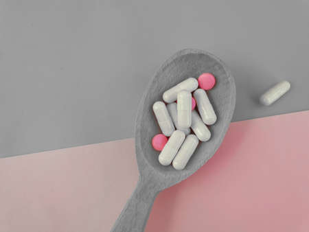 wooden spoon, collagen capsules on a colored backgroundの写真素材