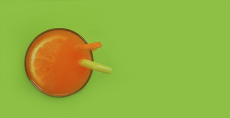orange juice with a straw on a colored backgroundの写真素材