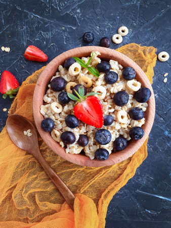 oatmeal, blueberries, strawberries on a concrete backgroundの写真素材