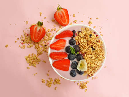 yogurt, granola, strawberry, blueberry on a colored backgroundの写真素材