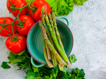 empty saucepan, asparagus, tomato, herbs on concrete backgroundの写真素材