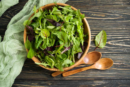 green salad leaves in a plate on a wooden backgroundの写真素材