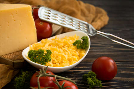 grated cheese, parsley on a wooden backgroundの写真素材