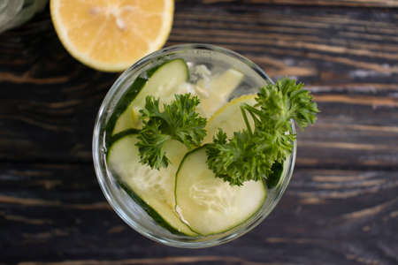 glass of water lemon, cucumber, parsley on wooden backgroundの写真素材