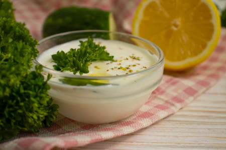 tzatziki sauce, lemon, cucumber on concrete background