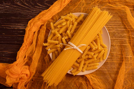 dry spaghetti on wooden background nutritionの写真素材