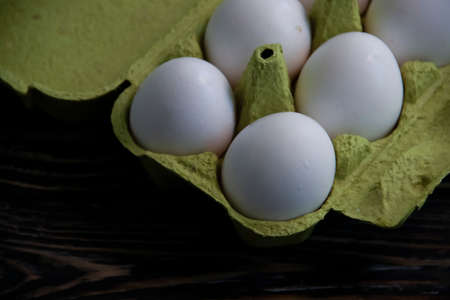 eggs in paper packaging on wooden background