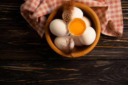 chicken eggs, feather on wooden background farm