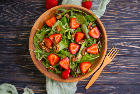 salad with strawberries, nuts on a wooden backgroundの写真素材