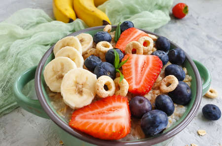 oatmeal, banana, strawberry, blueberry on concrete backgroundの写真素材