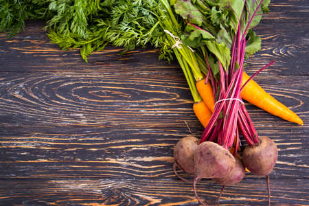 whole beet and carrot on a wooden backgroundの写真素材