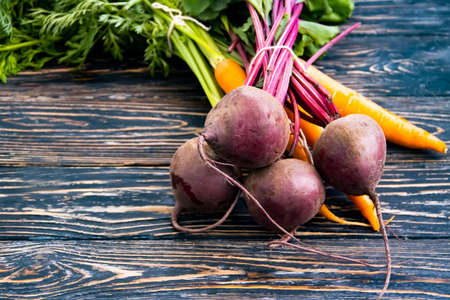 whole beet and carrot on a wooden backgroundの写真素材