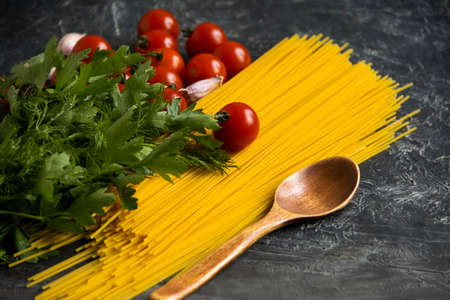 dry spaghetti, tomato on a concrete backgroundの写真素材