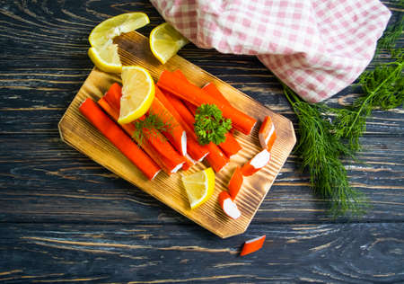Crab sticks, parsley on a wooden tableの写真素材