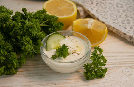 tzatziki sauce, lemon, cucumber on concrete background