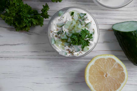 tzatziki sauce, lemon, cucumber on concrete background