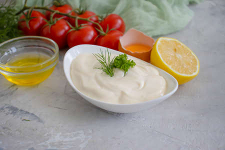 homemade mayonnaise, lemon, tomato on concrete backgroundの写真素材