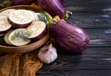 pieces of raw eggplant on wooden backgroundの写真素材