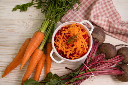 grated raw carrots and beet on a wooden backgroundの写真素材