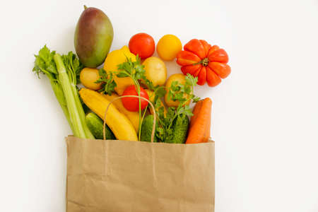 paper bag, vegetables and fruits on a white background