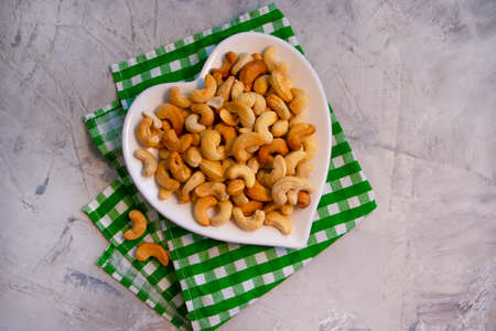 cashew nuts in a plate on a concrete background, heartの写真素材