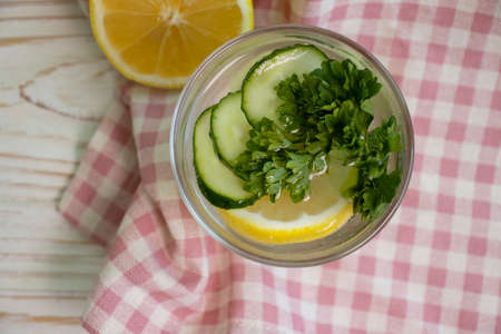 water with lemon, cucumber, parsley on a wooden backgroundの写真素材