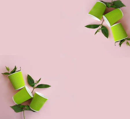 paper cup, green branch on a colored background