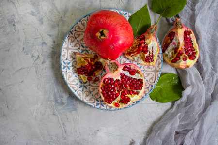 pomegranate fruit in a plate on a concrete backgroundの写真素材