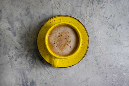 yellow cup of cappuccino on concrete backgroundの写真素材