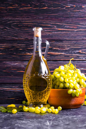 bottle of white wine, grapes on wooden backgroundの写真素材
