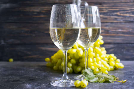 glass of white wine grapes on a concrete backgroundの写真素材