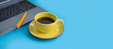 cup of coffee, laptop on a colored backgroundの写真素材